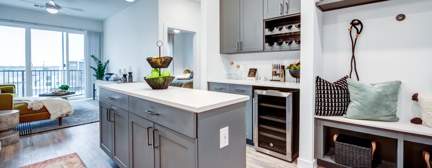 Kitchen island with wine fridge and storage area and view of the living room