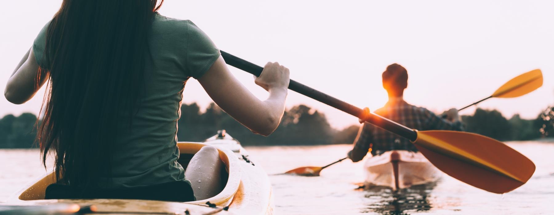 a woman and a man paddling a canoe on a lake
